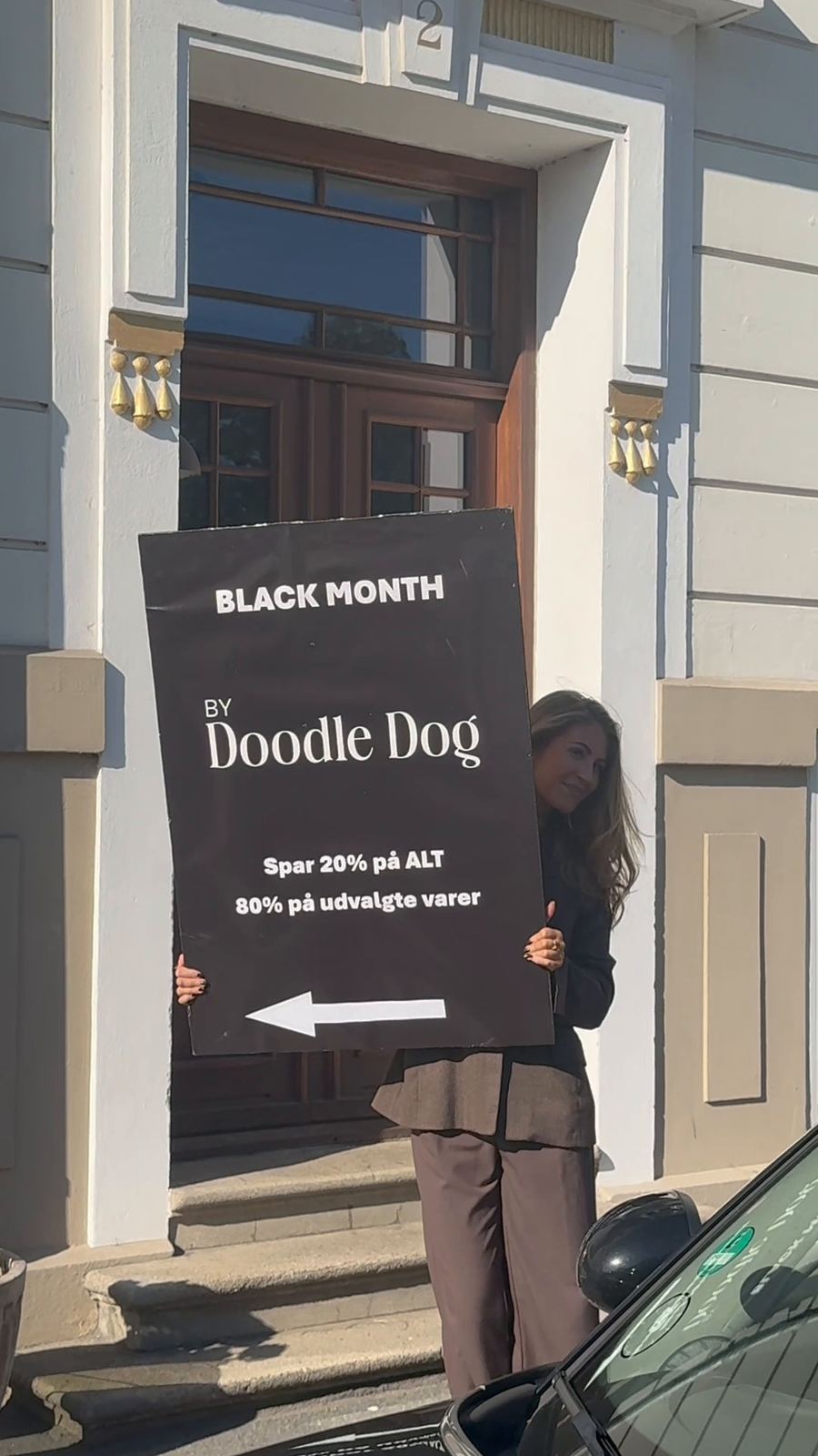 Laura med Black Month-skiltet på gaden